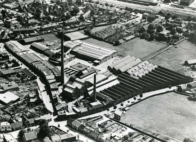 Luchtfoto van het Osse bedrijfscomplex Gebroeders Van den Bergh, beter bekend onder de merknaam “Bergoss”,  gezien vanuit het westen. (Foto: KLM Aerocarto, 1953, Stadsarchief Oss)