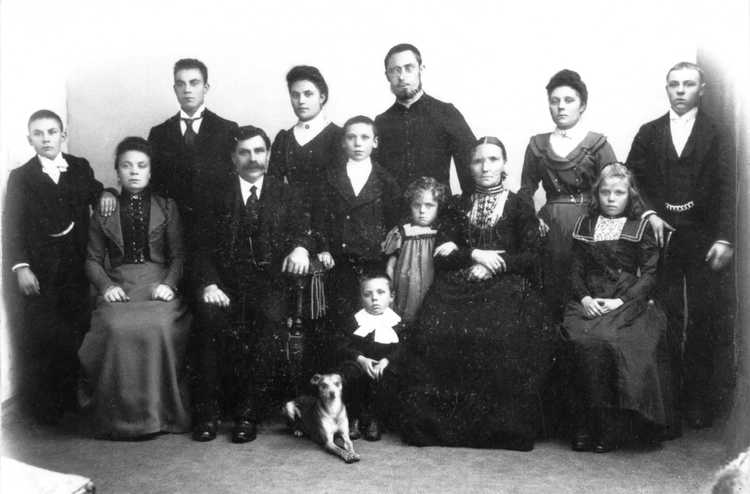 Een familiefoto van de familie Rutte voor het vertrek van Henri, die achteraan in het midden staat, met baard en bril (Foto: fotograaf onbekend, 1900)