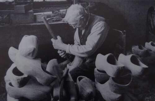 Daan van de Sande boort omstreeks 1960 nog handmatig een klomp uit in de klompenmakerij van Piet van de Wiel aan de Hamsestraat. (Foto: Collectie Erfgoedvereniging Kèk Liemt)