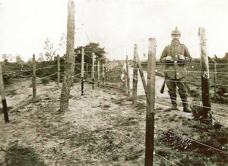 Duitse soldaat aan de elektrische draadversperring bij Baarle-Nassau.