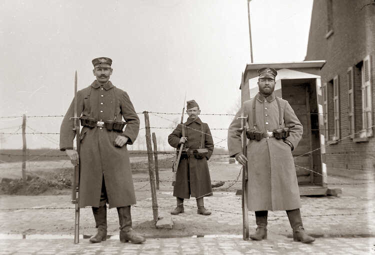 Twee Duitse soldaten voor de Nederlandse prikkeldraadversperring bij Nispen.